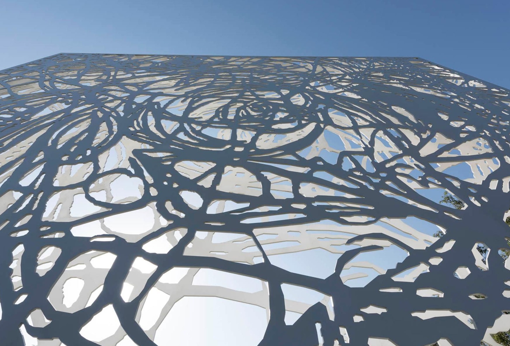 Fachada metálica perforada de diseño conceptual con patrón orgánico