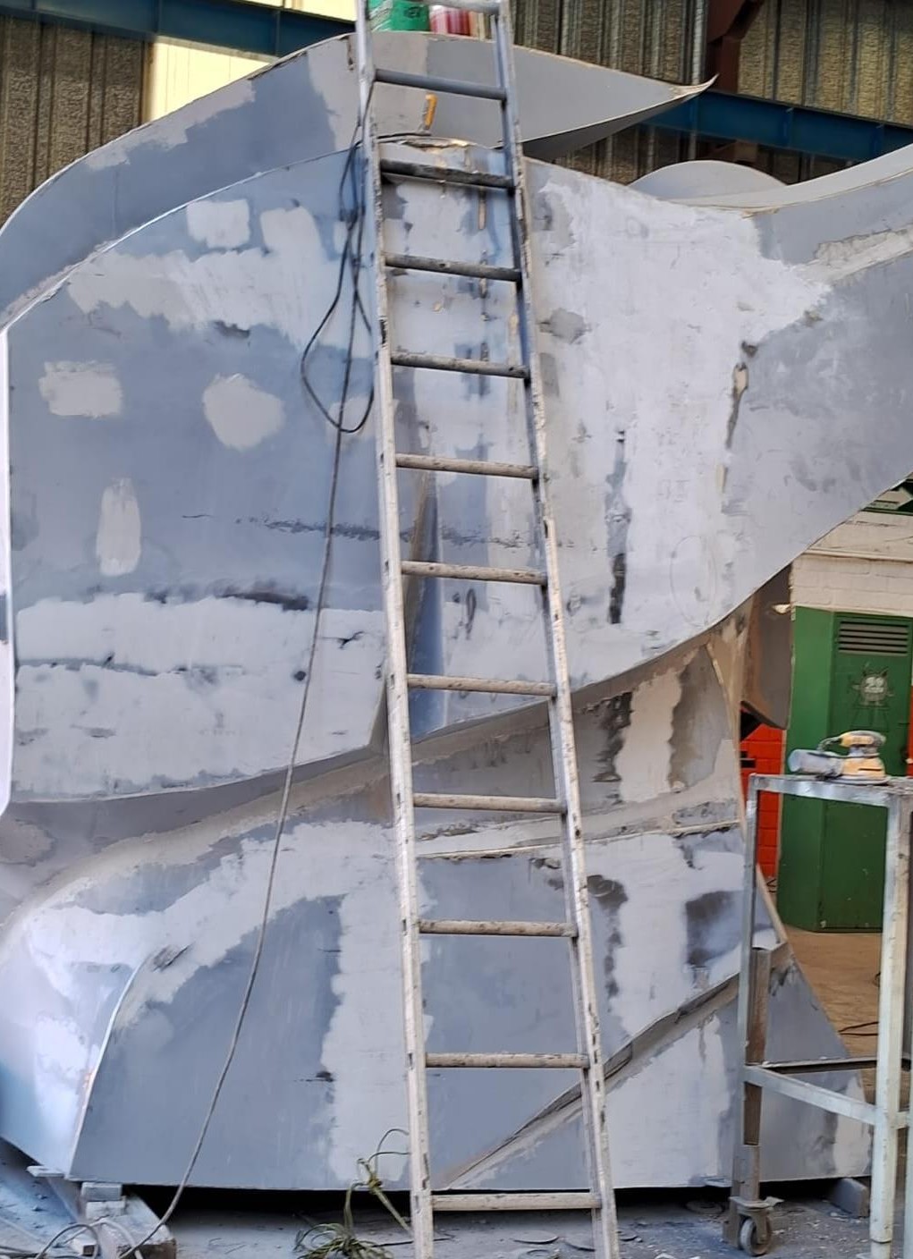 Escultura metálica en acabado con escalera de trabajo