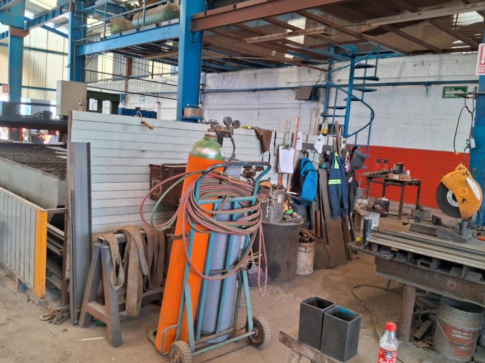 Área de soldadura con equipos y cilindros de gas en taller